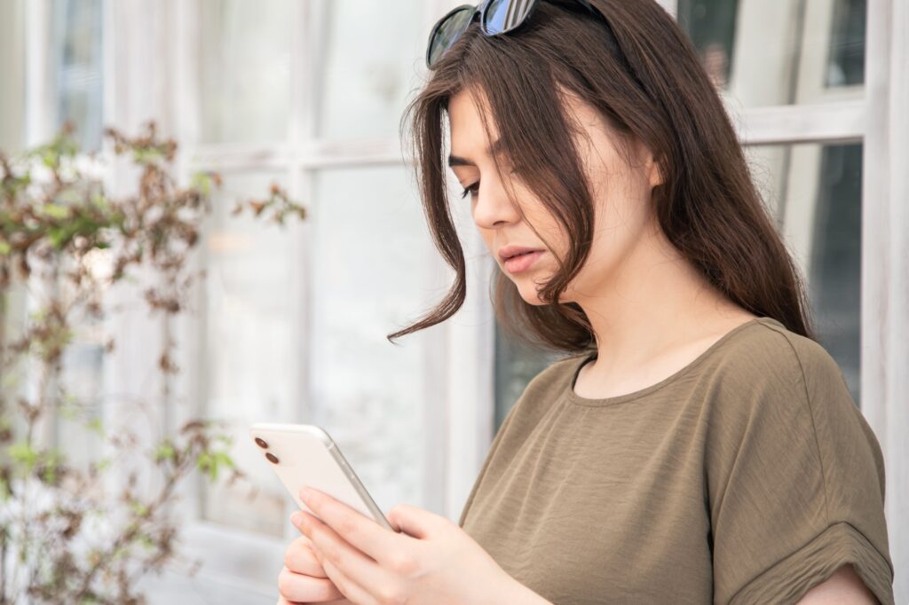 Business young woman with a smartphone in her hands on a hot summer day.