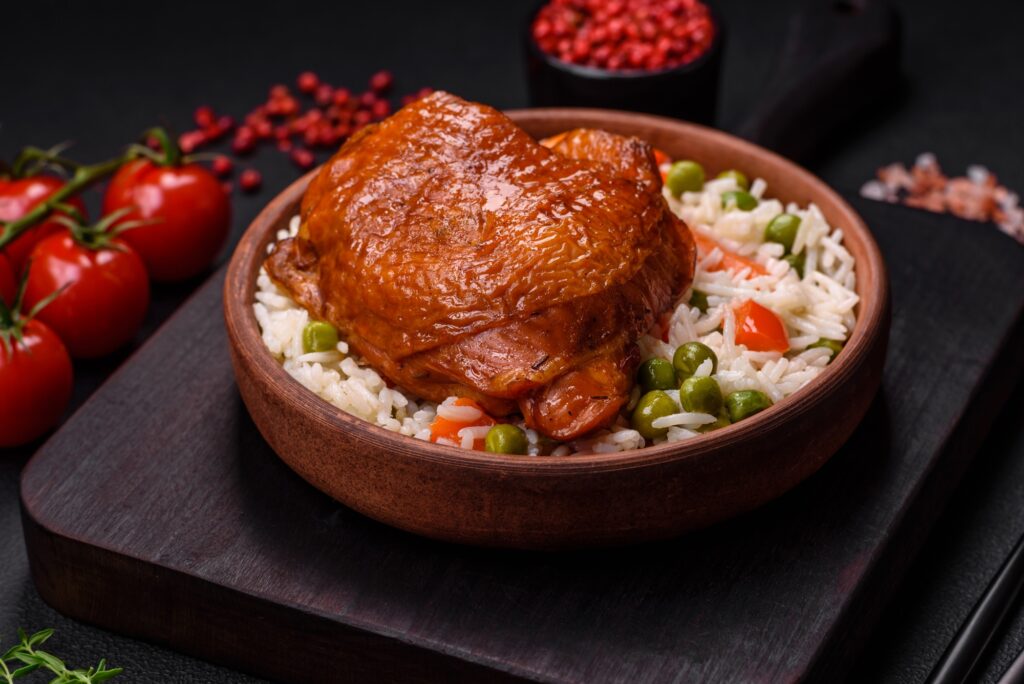 Delicious boiled rice with chicken and vegetables or risotto with salt, spices and herbs