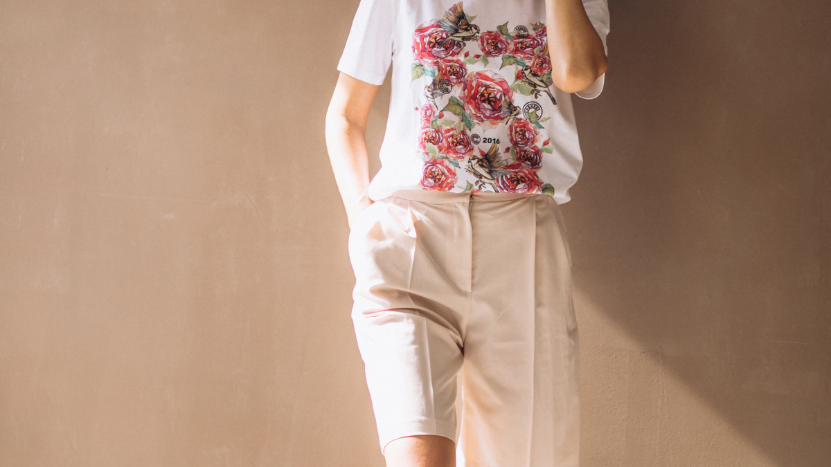 une femme, porte un t shirt manche courte avec un short beige